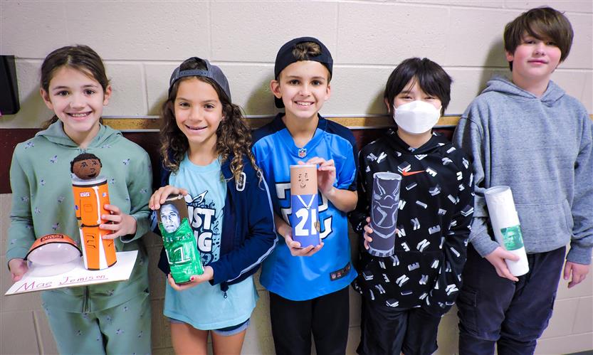 Students hold up Characters in a Can